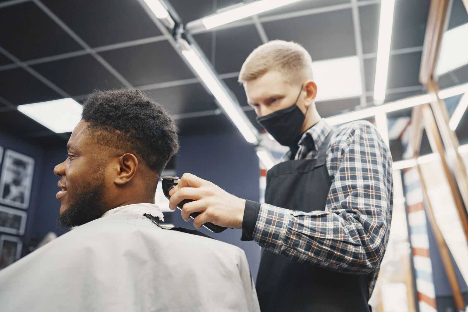 Barber giving a client a precise fade in a modern neighborhood shop