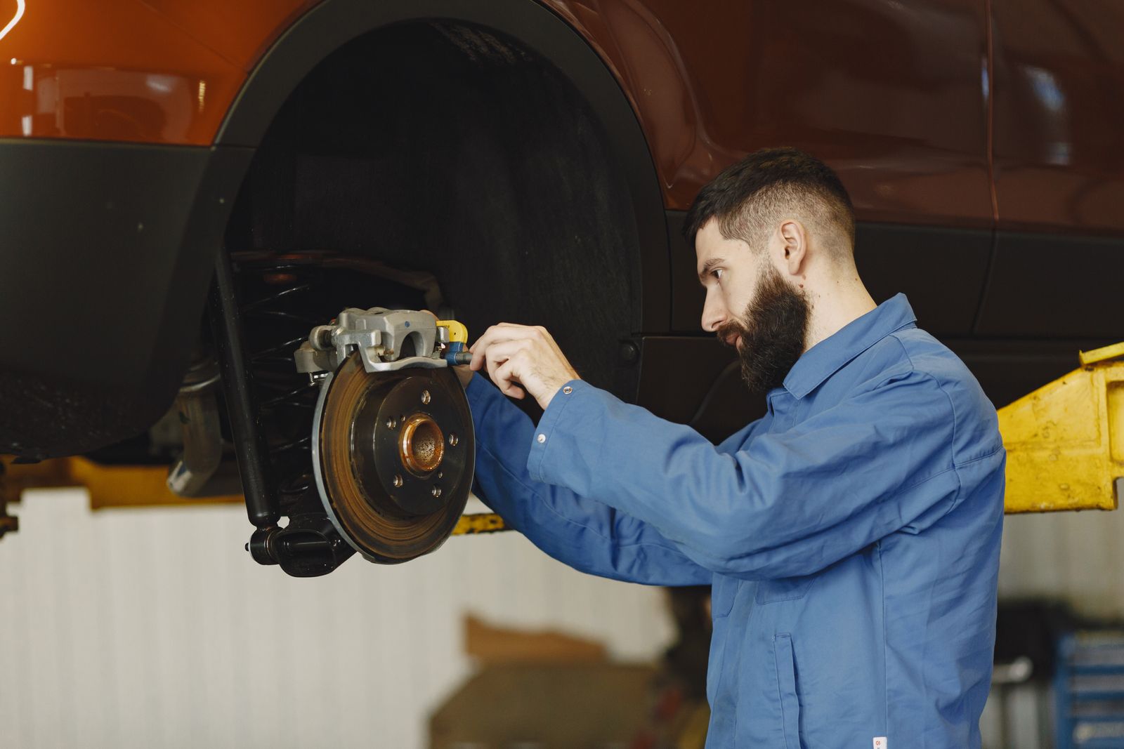Mechanic inspecting a vehicle brake assembly in a clean repair shop